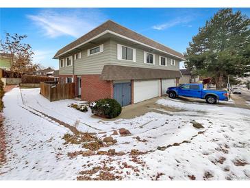 Two-story home with attached garages, brick accents, and siding under a blue sky at 9976 Appletree Pl, Thornton, CO 80260