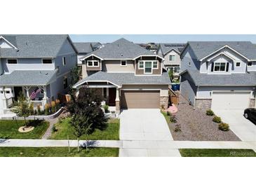 Beautiful two-story home with a large driveway, well-manicured lawn, and appealing landscaping at 17955 E 107Th Pl, Commerce City, CO 80022
