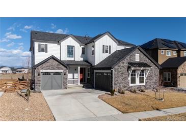 Charming two-story home featuring a three-car garage, stone accents, and a well-manicured front yard at 751 Green Mountain Dr, Erie, CO 80516