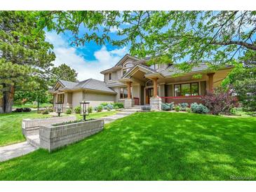 Stunning two-story home featuring a lush green lawn and charming architectural details at 2252 S Queen St, Lakewood, CO 80227