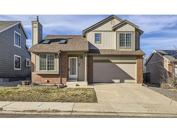 Two-story brick home with attached garage and landscaped front yard at 9125 Bell Flower Way, Highlands Ranch, CO 80126