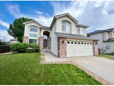 Inviting two-story home with a well-manicured lawn and a two-car garage in a residential neighborhood at 12566 Dexter St, Thornton, CO 80241