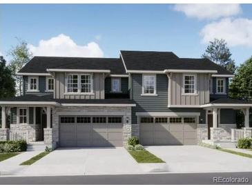 Attractive townhome with stone accents, a gray color palette, and a two car garage at 6770 Juniper Dr, Thornton, CO 80602
