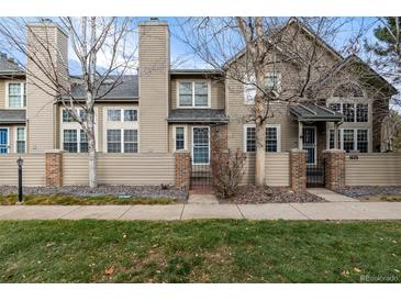 Tan two-story townhome with brick accents and landscaping at 1673 S Fulton St, Aurora, CO 80247