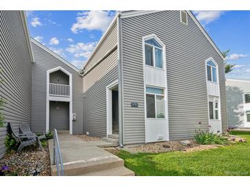 Gray two-story townhouse featuring stylish windows, green lawn, and a welcoming entrance at 3331 S Monaco Pkwy # D, Denver, CO 80222