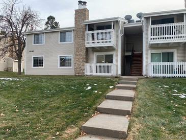 Two-story condo building with grassy yard and stairs leading to entrance at 14141 E Jewell Ave # 102, Aurora, CO 80012