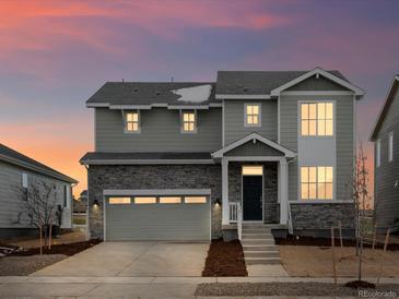 Charming two-story home boasts stone accents, a gray exterior, and a well-manicured front yard at 24008 E Atlantic Pl, Aurora, CO 80018