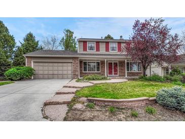 Charming two-story home with brick exterior, landscaped yard, and a two car garage at 7100 S Hudson Cir, Centennial, CO 80122