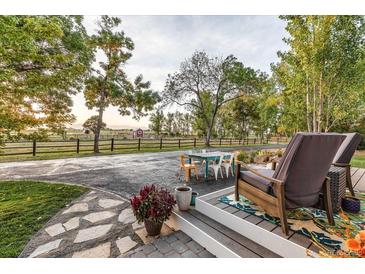 Relaxing patio furniture overlooks a fenced-in yard with distant mountain views at 10876 Maple Rd, Lafayette, CO 80026