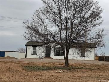 Newly remodeled single Gathering house with fresh white paint, black trim and a mature tree in front at 7486 Harold St, Fort Lupton, CO 80621