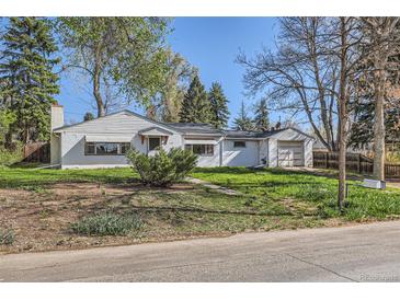 Charming single-story home with a detached garage and a well-maintained front yard on a sunny day at 7785 Westview Dr, Lakewood, CO 80214