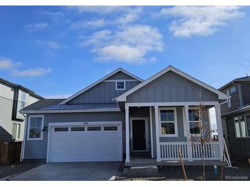 Gray exterior of charming craftsman style home with white trim and a two-car garage at 498 Grey Rock St, Brighton, CO 80601