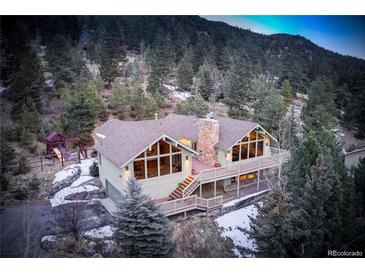 Charming mountain home with large windows, deck and stone chimney at 2218 Witter Gulch Rd, Evergreen, CO 80439