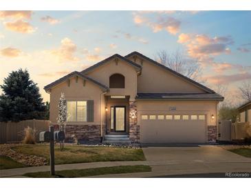 Charming single-story home featuring stucco siding, stone accents, manicured lawn, and a two-car attached garage at 418 Rifle Ct, Broomfield, CO 80020