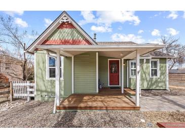 Charming home with a covered porch, red door, and quaint architectural details at 9551 W 38Th Ave, Wheat Ridge, CO 80033