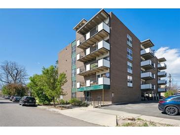 Brick apartment building featuring multiple balconies, front entrance, and manicured landscaping at 1265 Elizabeth St # 305, Denver, CO 80206