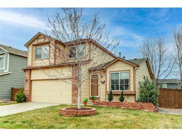 Charming two-story home with a well-manicured lawn and a brick-accented facade at 10652 Hyacinth St, Highlands Ranch, CO 80129