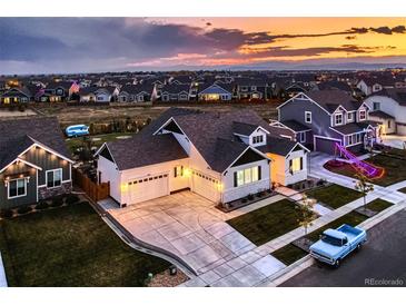 Stunning dusk shot of craftsman style home with three-car garage, blue truck, and mountain views at 405 Buckskin Rd, Berthoud, CO 80513
