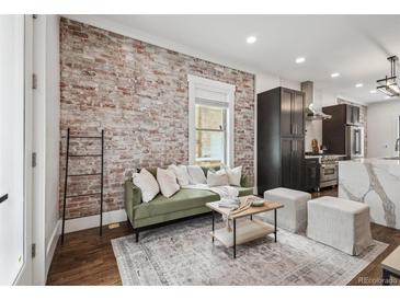 Cozy living room features exposed brick wall, modern furnishings, and hardwood floors at 1024 W 8Th Ave, Denver, CO 80204