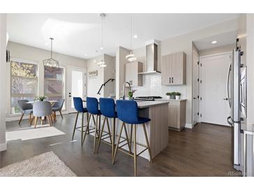 Modern kitchen featuring a large island with seating and stylish pendant lighting at 5026 S Platte River Pkwy, Littleton, CO 80123