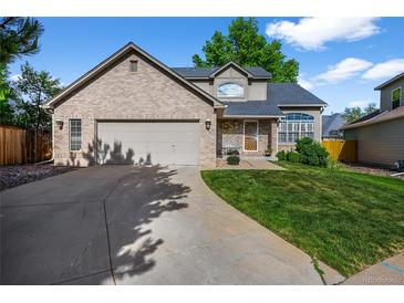 Charming brick home featuring a well-manicured lawn and a spacious two-car garage at 6454 S Nelson Way, Littleton, CO 80127