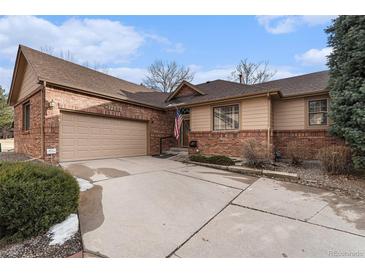 Charming single-Gathering home featuring a brick exterior, two-car garage, and well-manicured front yard at 7288 S Sundown Cir, Littleton, CO 80120