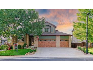 Inviting two-story home features a three-car garage, lush landscaping and a well-maintained lawn at 16873 Boreas Ct, Parker, CO 80134