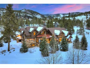 Spacious multi-story home with snow-covered roof, stone accents, and beautiful mountain views at 59 Gold Run Rd, Breckenridge, CO 80424