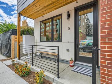 Inviting front porch with modern railings, wooden bench, and flowerbed leading to the front door at 4025 Jason St # 101, Denver, CO 80211