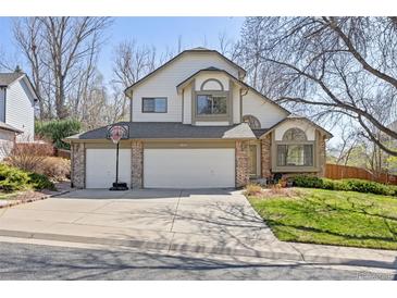 Charming two-story home with a three-car garage and basketball hoop on a sunny day at 6868 Johnson St, Arvada, CO 80004