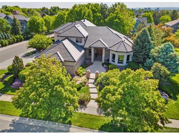 Stunning home featuring lush landscaping, a courtyard entry, and elegant architectural details on a sunny day at 5350 S Marshall St, Littleton, CO 80123