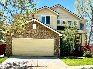 Charming two-story home featuring a stone-clad garage and well-maintained lawn at 5988 W Crestline Ave, Littleton, CO 80123