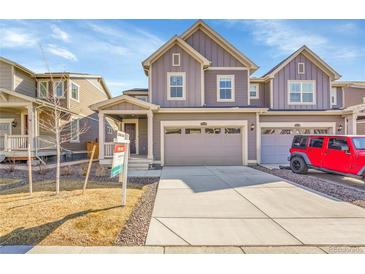 Charming gray two-story townhouse with a two-car garage and manicured front yard at 17836 Gallup St, Broomfield, CO 80023