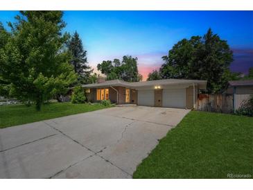 Charming single-story brick home with an attached two-car garage and a long driveway at 100 Dudley St, Lakewood, CO 80226