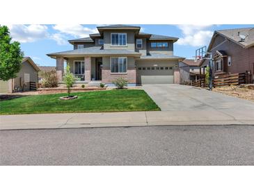 Charming two-story home with manicured lawn, a basketball hoop, and an attached two car garage at 22527 E Layton Cir, Aurora, CO 80015