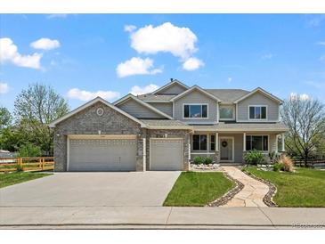 Charming two-story home featuring a landscaped front yard, gray brick, and an attached two-car garage at 708 Teal Cir, Longmont, CO 80503