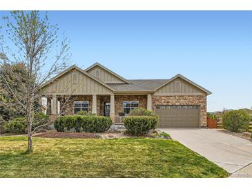 Charming single-story home with a stone and siding facade, complemented by a well-maintained lawn and landscaping at 6216 E 135Th Ave, Thornton, CO 80602