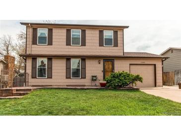 Charming two-story home with brown siding, well-maintained lawn, and attached garage at 17882 E Wyoming Pl, Aurora, CO 80017