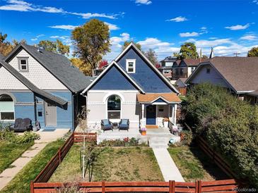 Charming blue two-story home with a well-manicured front yard and inviting front porch at 3317 W 37Th Ave, Denver, CO 80211