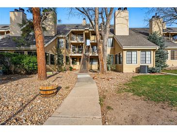 Inviting multi-story condo with well-maintained landscaping and a charming walkway to the entrance at 4878 E Kentucky Ave # B, Denver, CO 80246