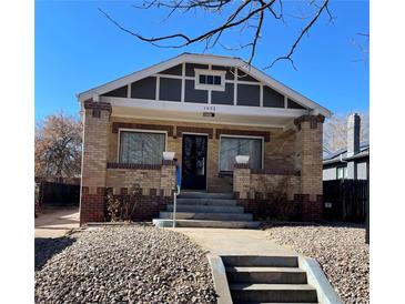 Brick house with a gray roof, front porch, and landscaping at 1453 Utica St, Denver, CO 80204