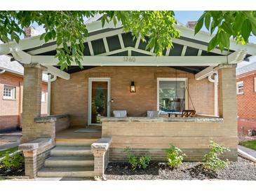 Inviting front porch with brick columns and a wooden swing at 1260 Adams St, Denver, CO 80206