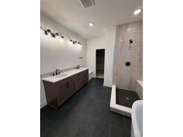 Modern bathroom featuring double vanity, walk-in shower with tile accents and black fixtures at 5626 W 142Nd Ave, Broomfield, CO 80020
