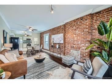Inviting living room featuring exposed brick wall, modern decor, and an open concept to the dining area at 3956 Kalamath St, Denver, CO 80211