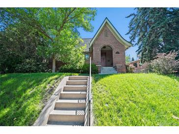 Charming brick home with a landscaped front yard and steps leading to the front door at 1278 Dexter St, Denver, CO 80220