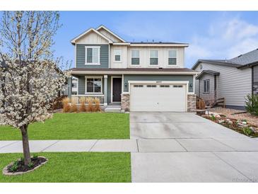 Charming two-story home featuring a well-manicured lawn and attached two-car garage at 18077 E 99Th Ave, Commerce City, CO 80022