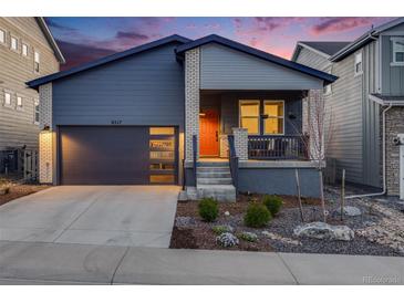 Charming single-Gathering home boasts a modern design, landscaping, and a welcoming orange front door at 8517 Eckley St, Littleton, CO 80125