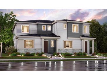 A modern two-story home with gray and white siding and a stone facade, complemented by manicured landscaping at 14127 Deertrack Ln, Parker, CO 80134