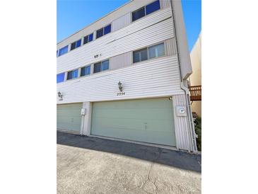 Exterior view of a light-colored townhouse with attached garage and landscaping at 2354 S Troy St, Aurora, CO 80014