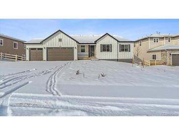 Stunning farmhouse exterior with a snow covered yard at 5009 Hickory Oaks St, Castle Rock, CO 80104